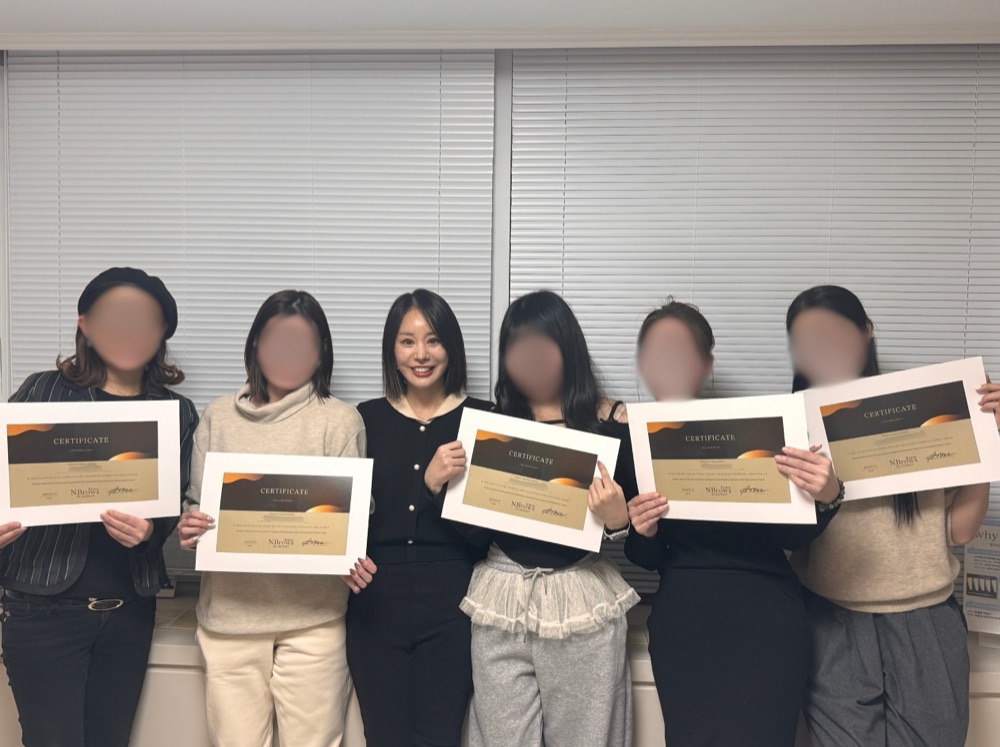 修了証を手にした受講生と講師